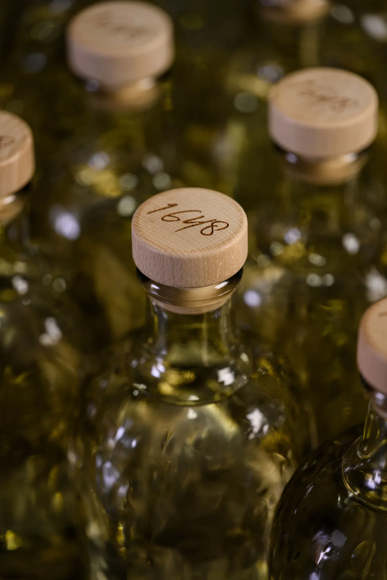 Rows of filled bottles with wooden corks, each hand-numbered